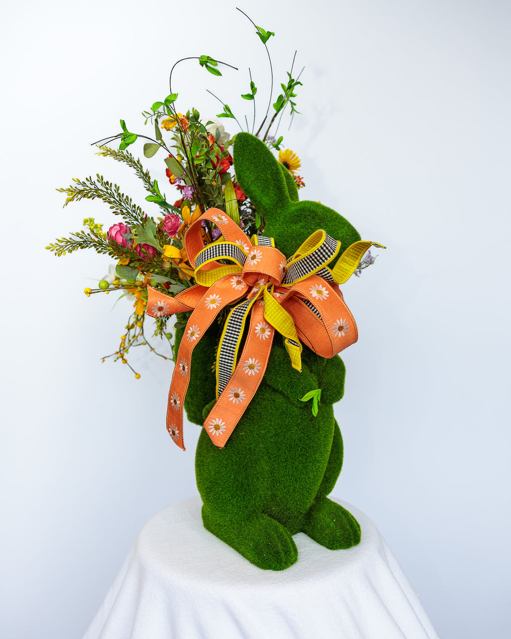 Moss-covered bunny planter with spring florals and bow