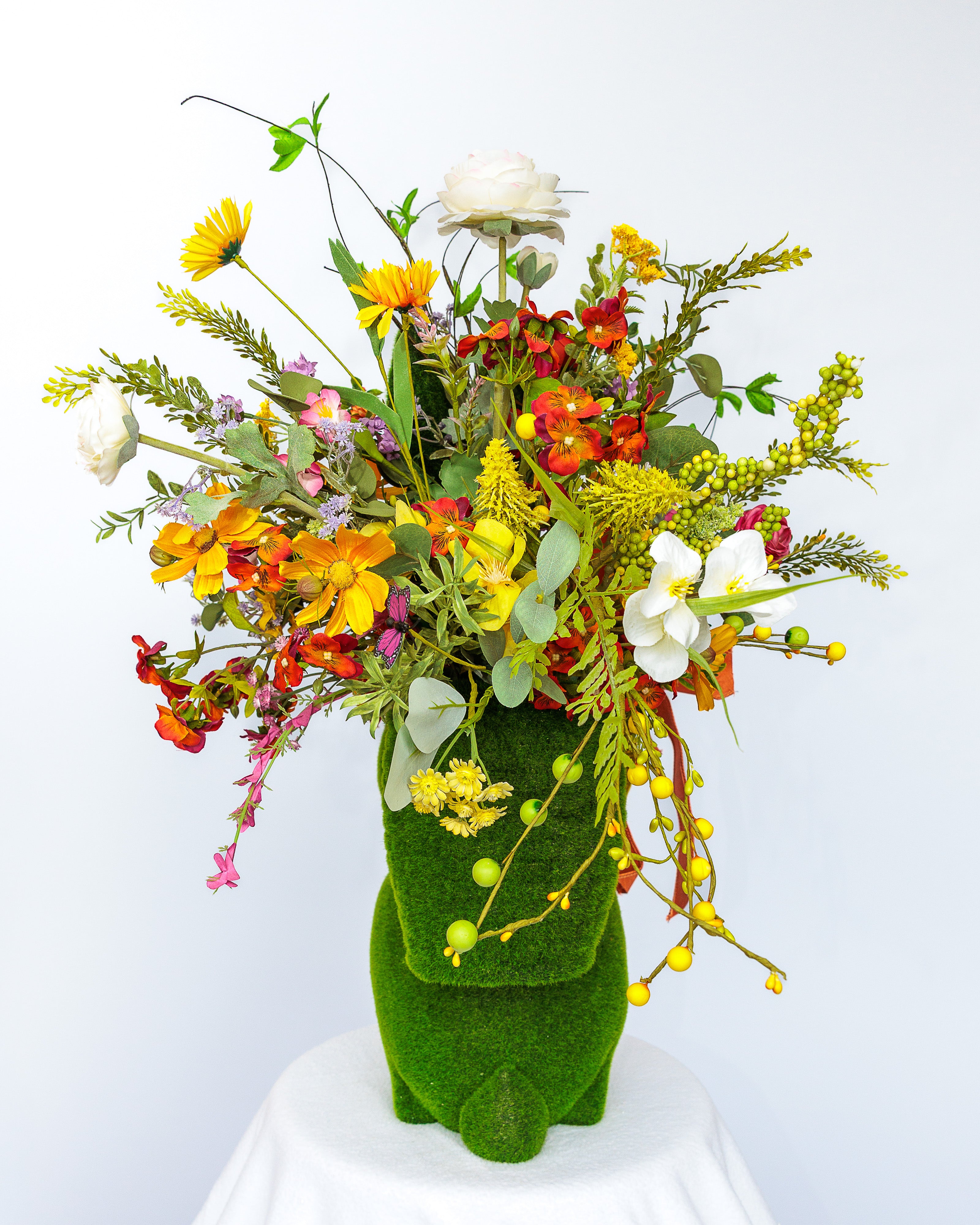 Moss-covered bunny planter with spring florals and bow